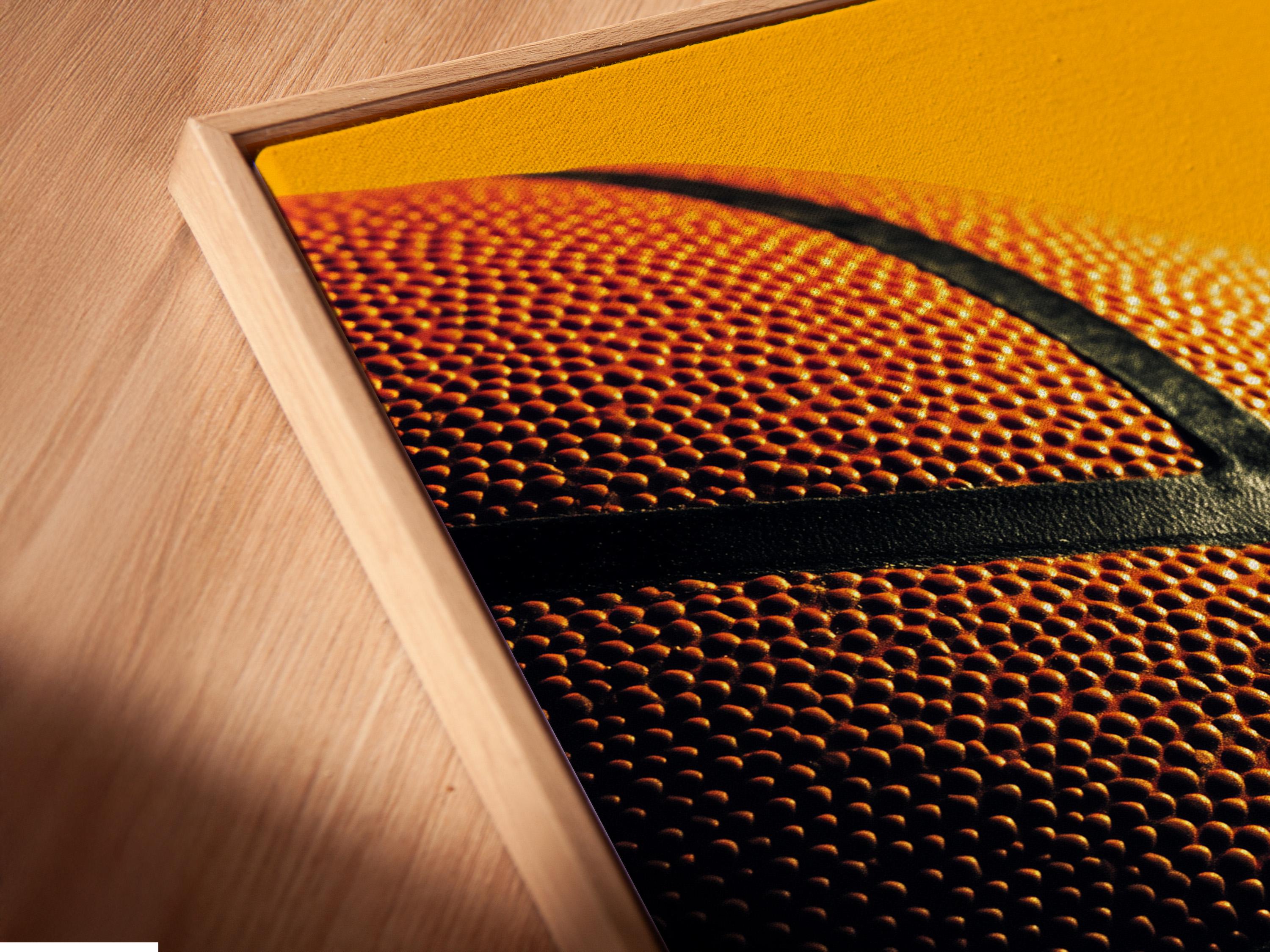 Close-up basketball surface with orange dimples and dark curved grooves