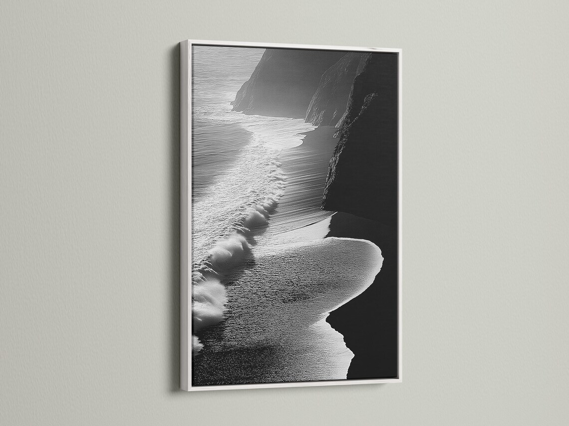 A monochrome seascape shows foamy wave textures breaking along a shoreline, with dark cliff-like shapes framing the scene detail view