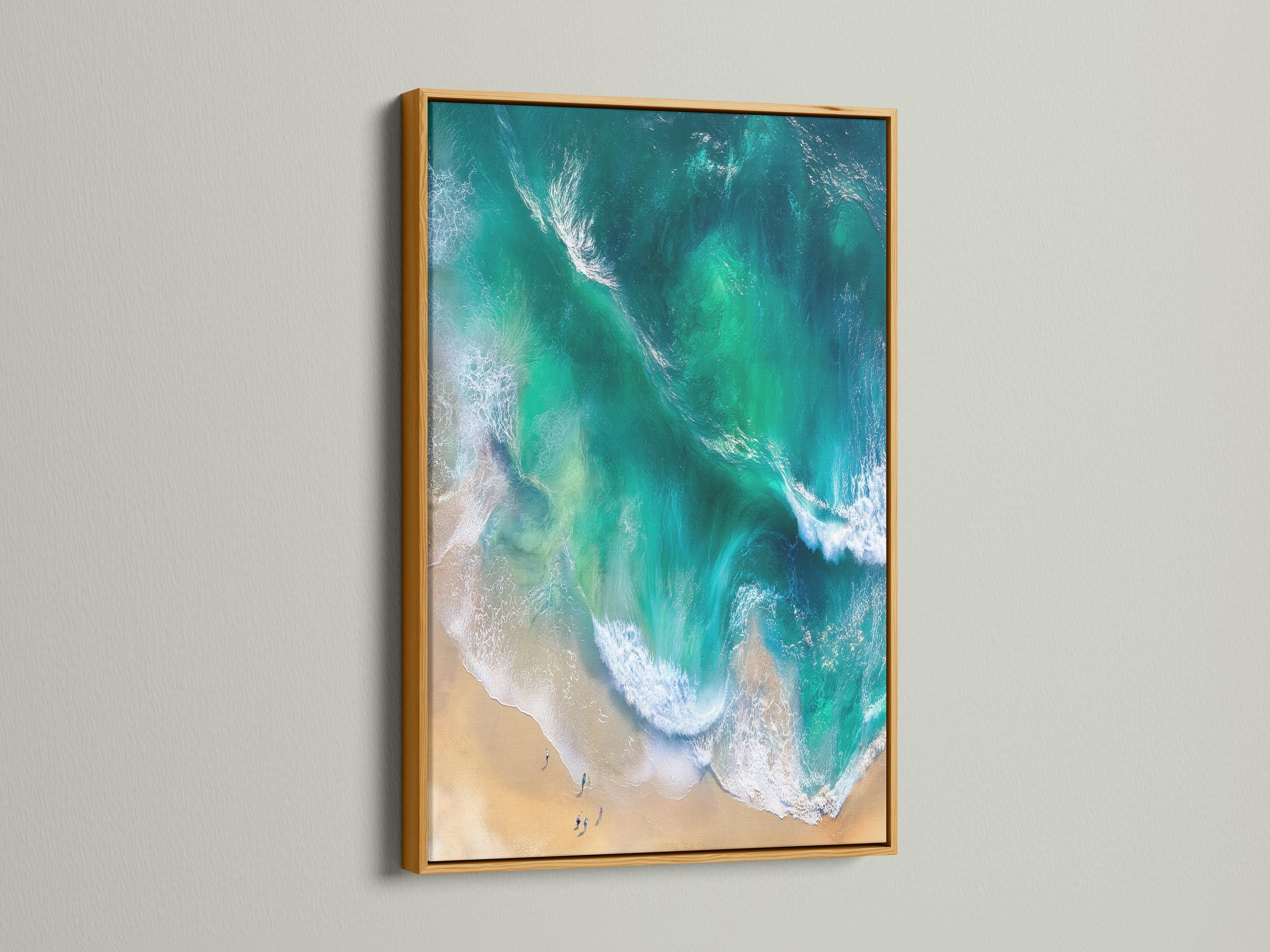 Aerial view of turquoise ocean waves with white foam meeting a sandy beach detail view
