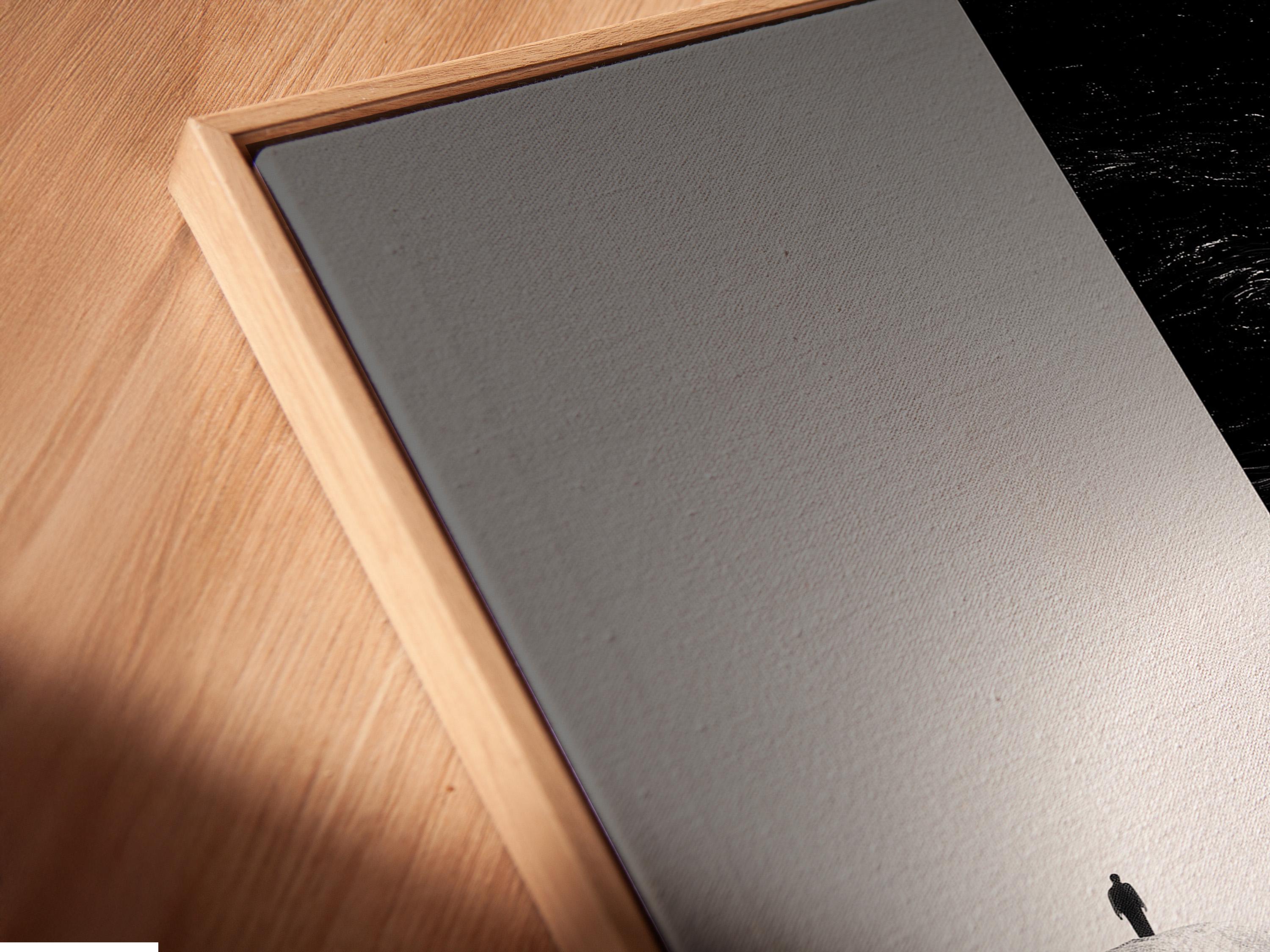 Room mockup showing monochrome framed artwork with a small standing figure and swirling black area