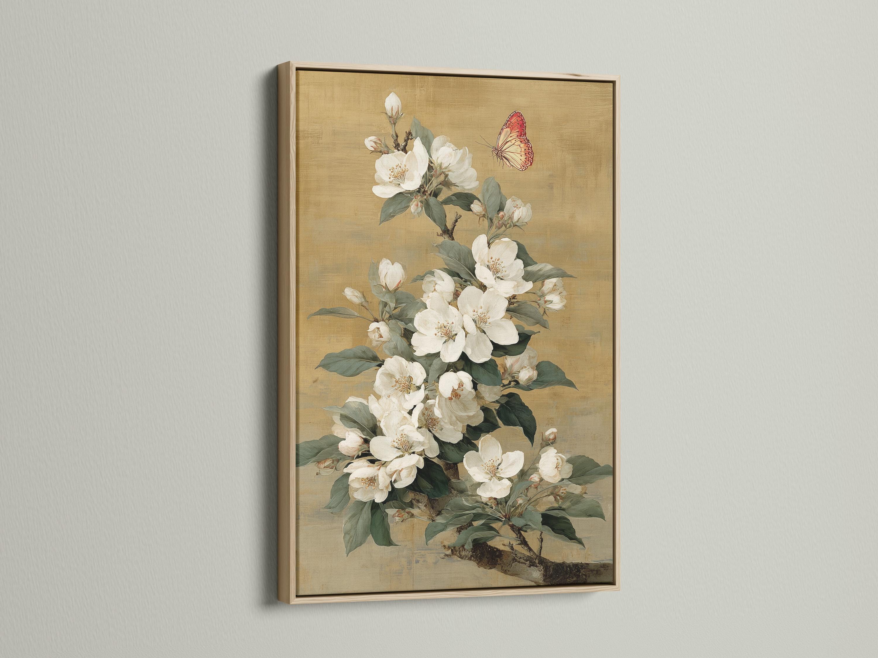 Vertical framed artwork mockup on a light wall with a bouquet of white blossoms and a butterfly