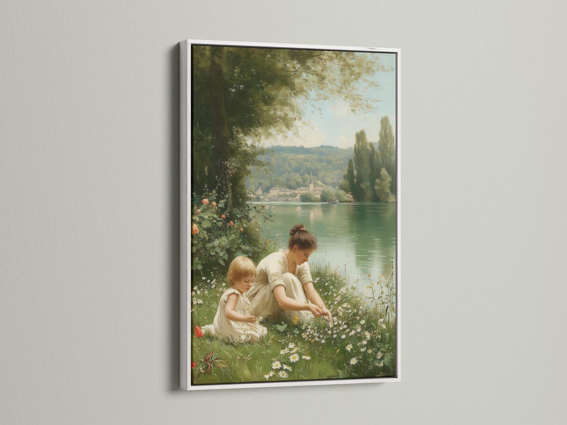 Mother and child sitting in a meadow by a calm lake with trees and distant buildings detail view