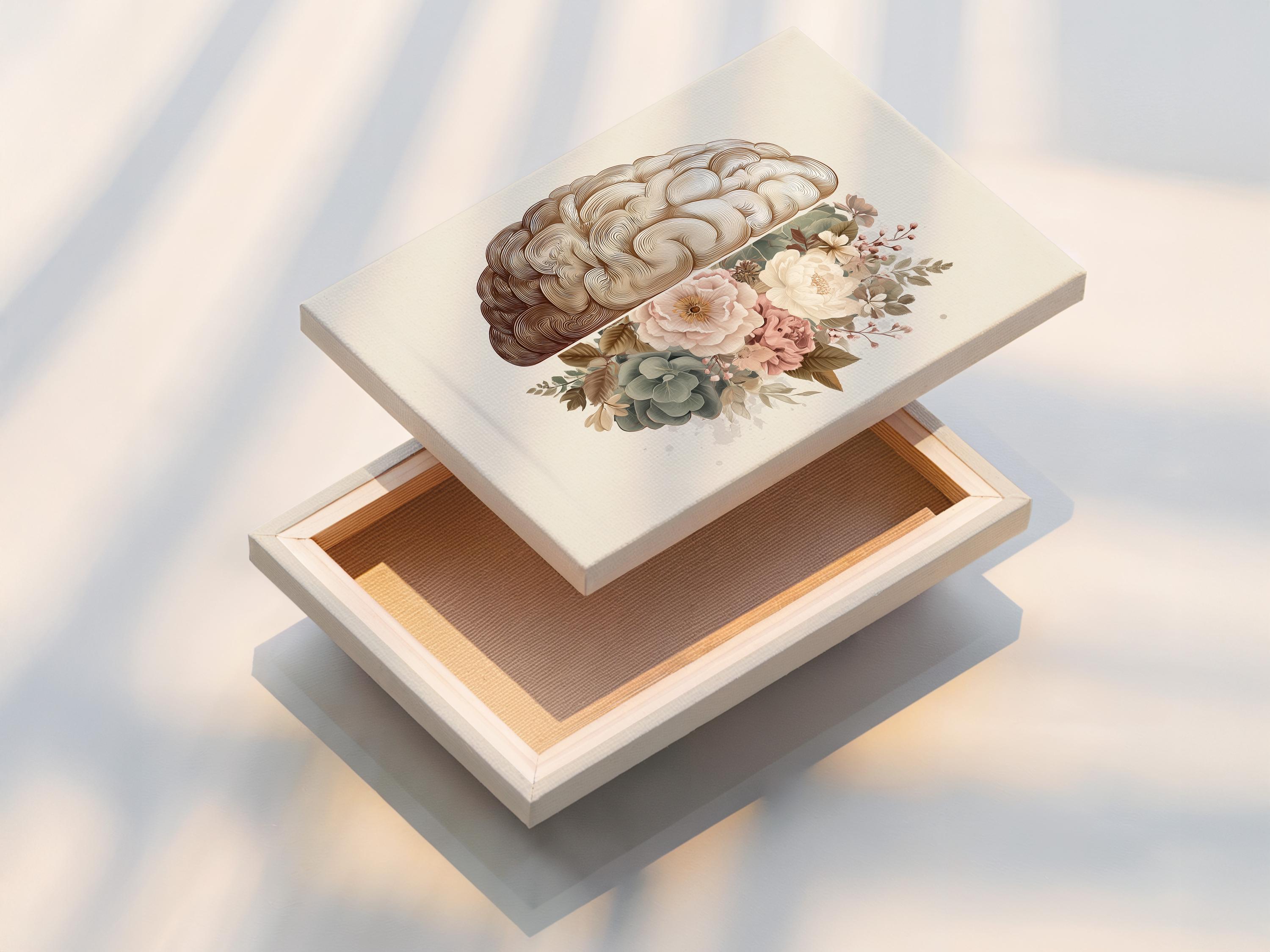 Person reading beside a framed split brain and floral artwork on a floor in a softly lit room