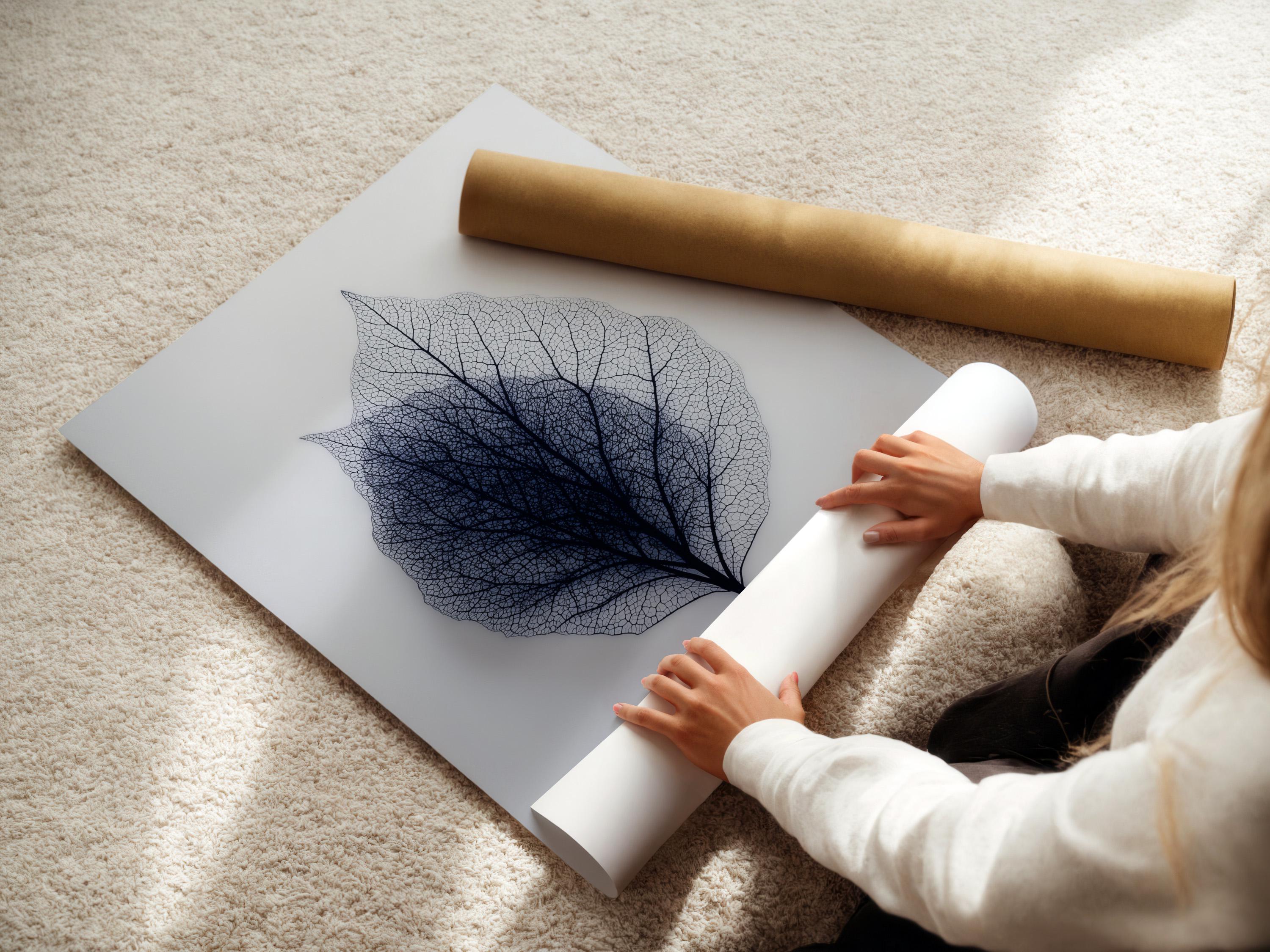 A person looking at a framed leaf skeleton wall artwork in a bright room