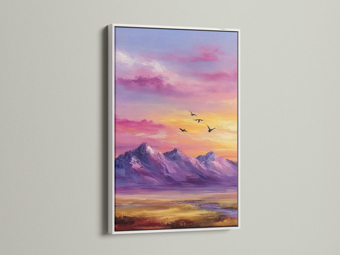 A framed mountain sunset illustration with purple, pink and gold skies and small black birds detail view