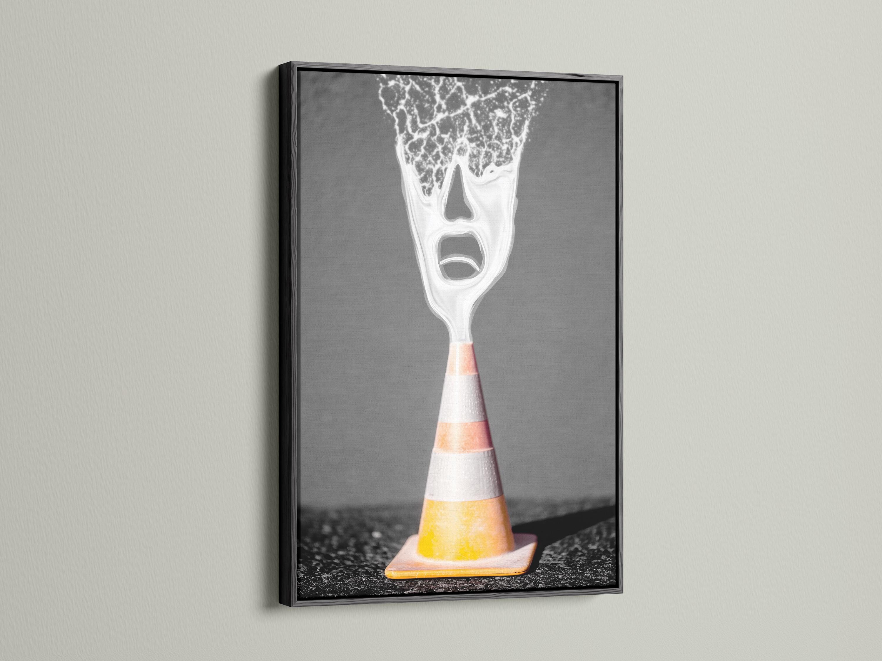 A surreal traffic cone stands on dark ground, its top appearing as a screaming white face with high-contrast, graphic detailing detail view