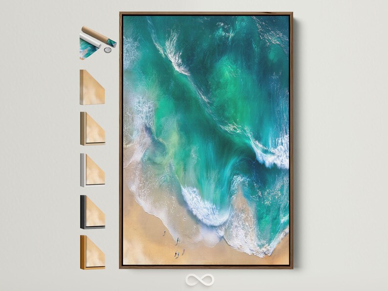 Aerial view of turquoise ocean waves with white foam meeting a sandy beach