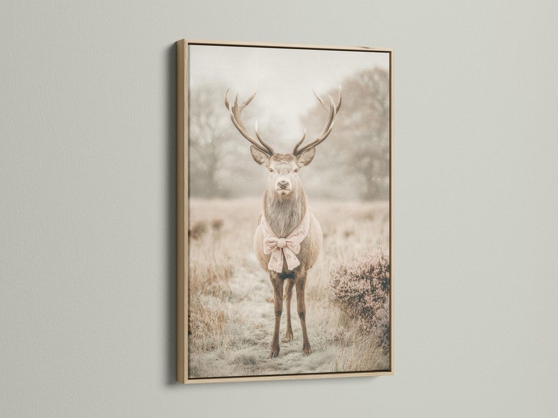 Deer portrait with raised antlers in a misty field, wearing a pale pink bow detail view