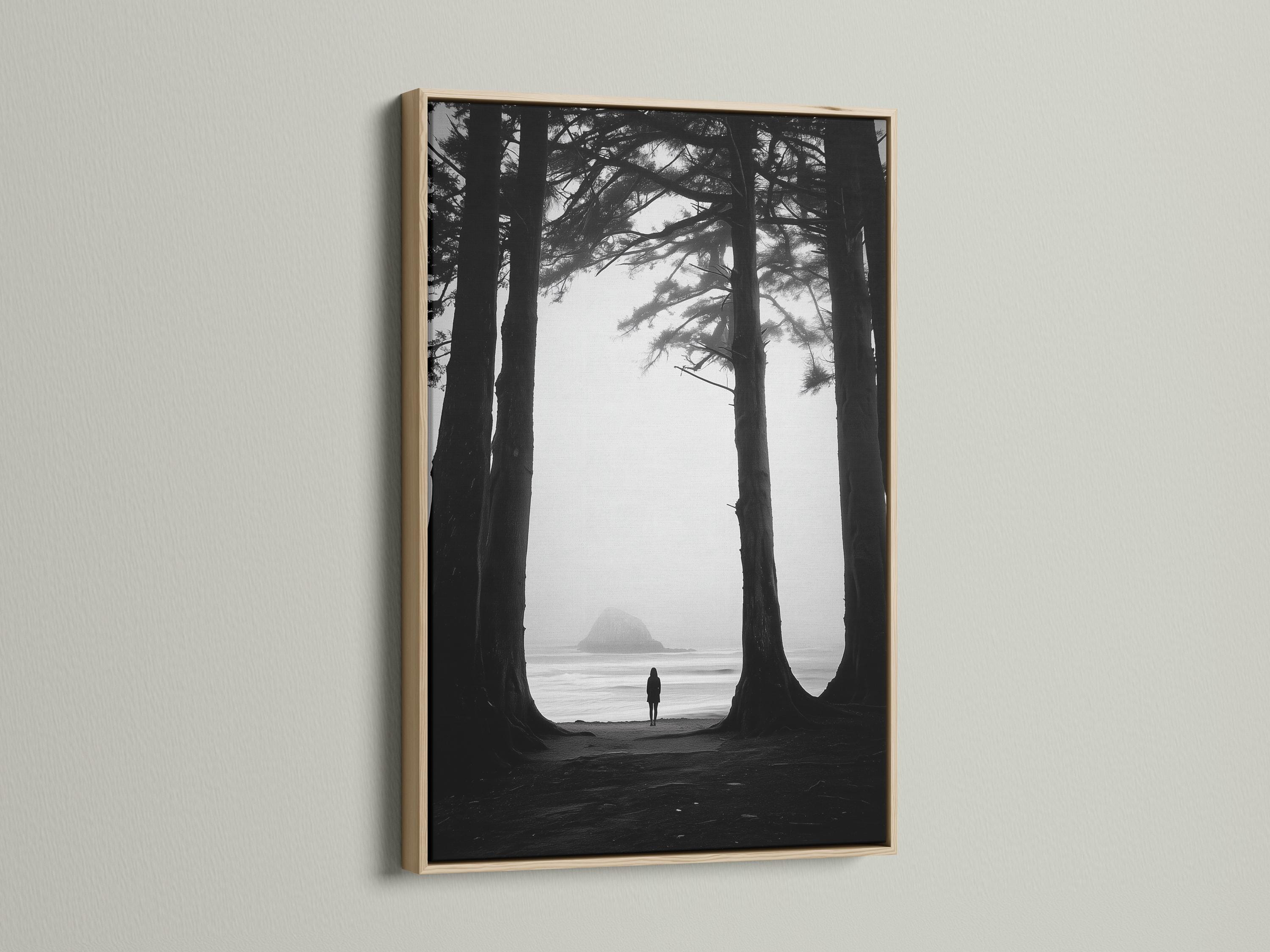 Monochrome seascape with dark tree trunks framing a foggy beach and a small lone figure detail view