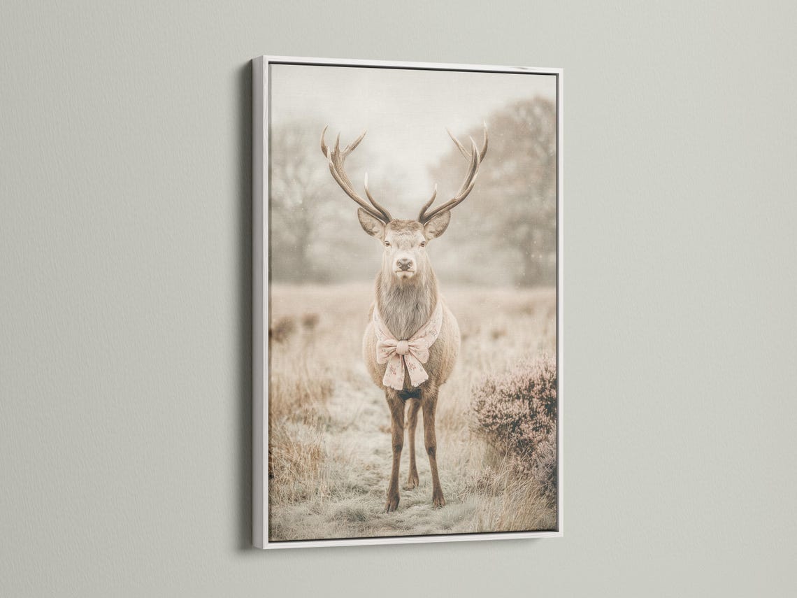 Deer portrait with raised antlers in a misty field, wearing a pale pink bow detail view