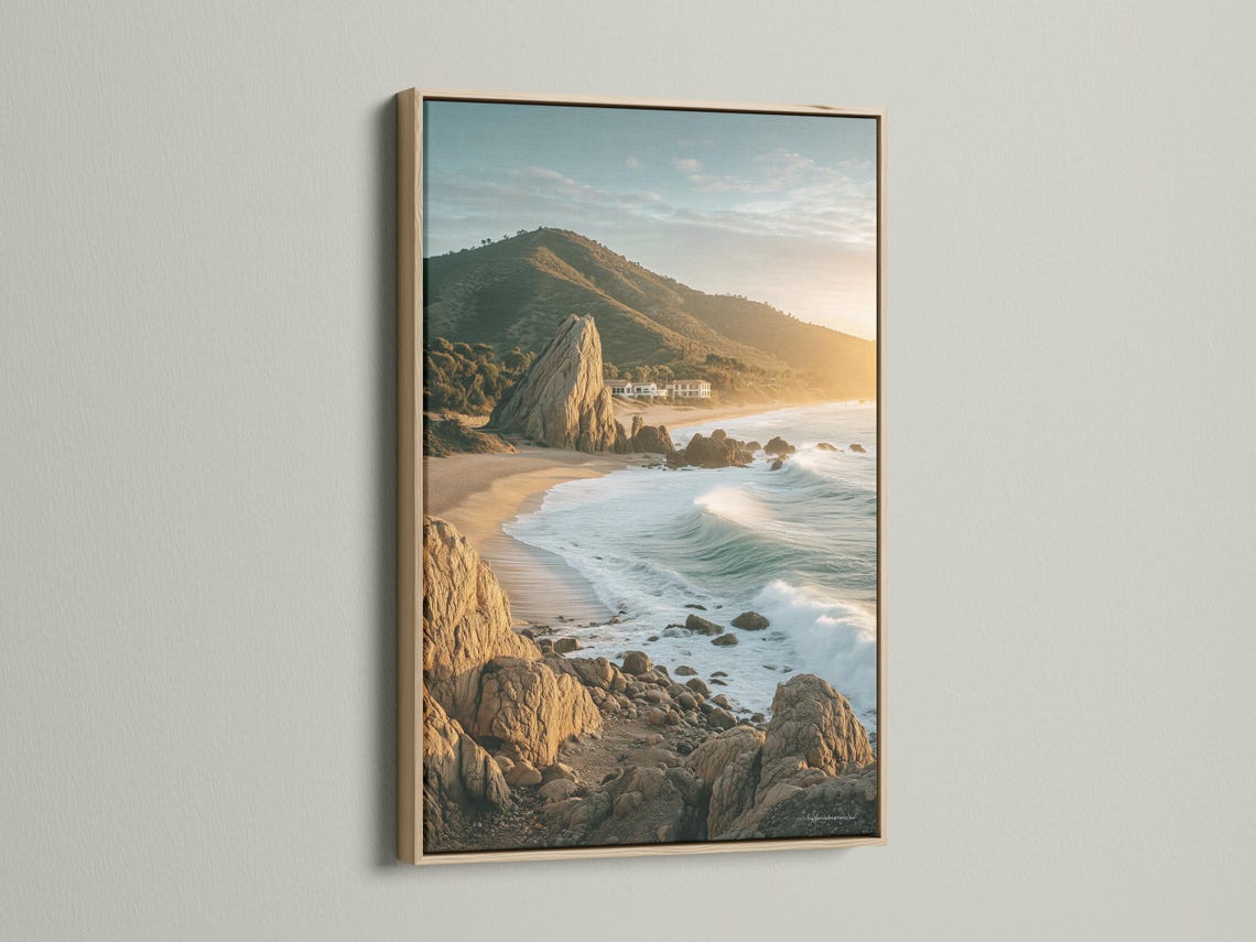 Golden hour seascape showing sandy shore, foamy waves, rocky cliffs and headland detail view