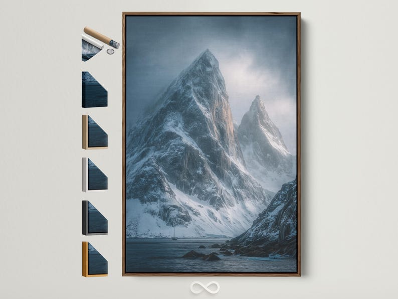 Blue misty mountain landscape with snow peaks, cloudy sky, and dark rocky shoreline