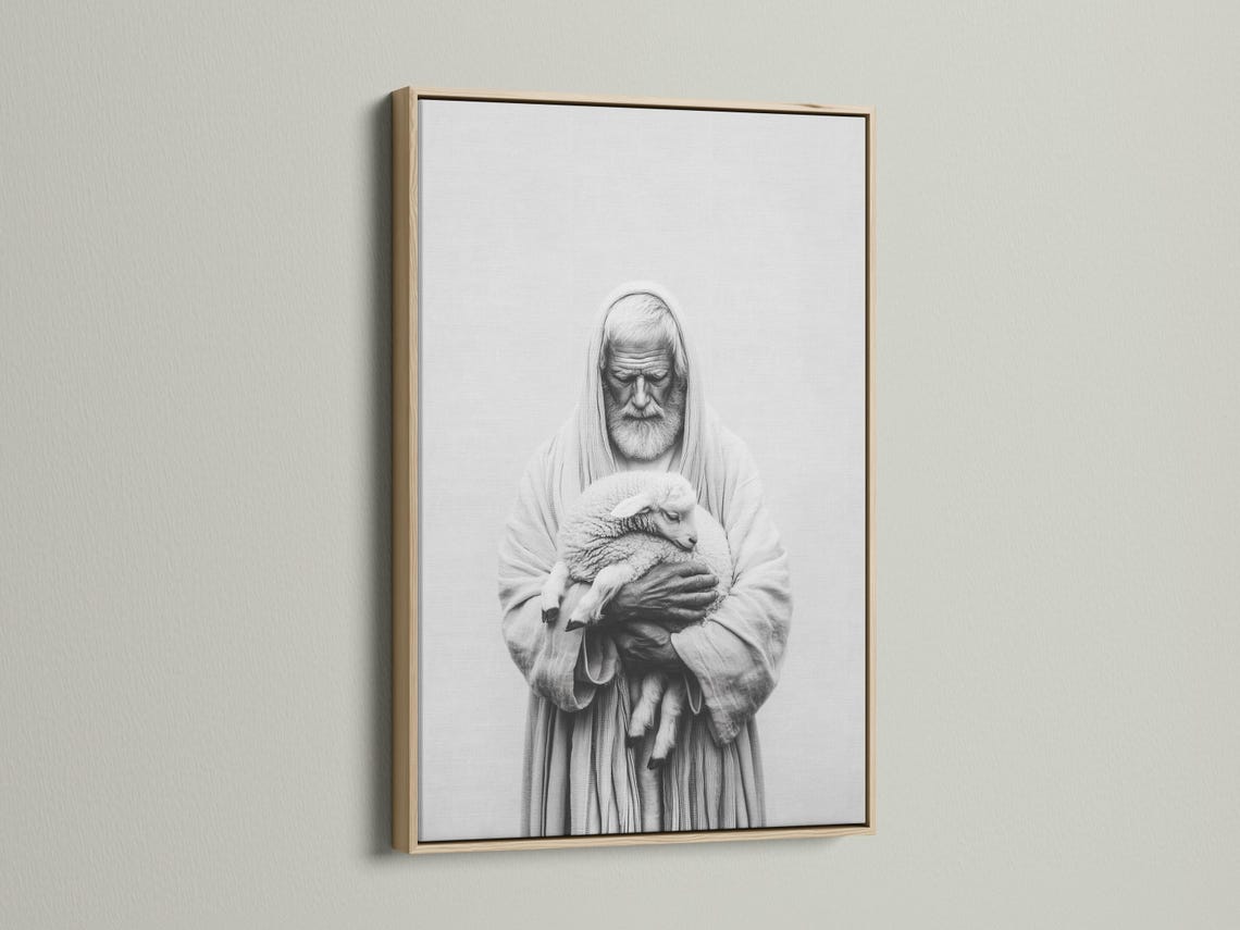Room mockup showing a framed black-and-white portrait of a hooded shepherd holding a lamb