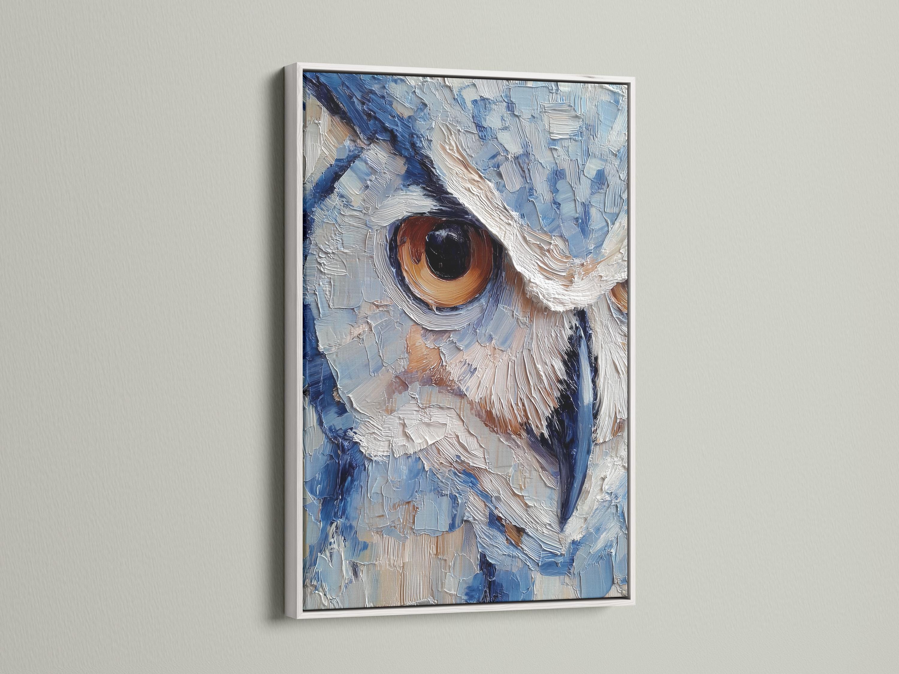 Room scene with a framed blue owl painting above a desk where a person writes in a book