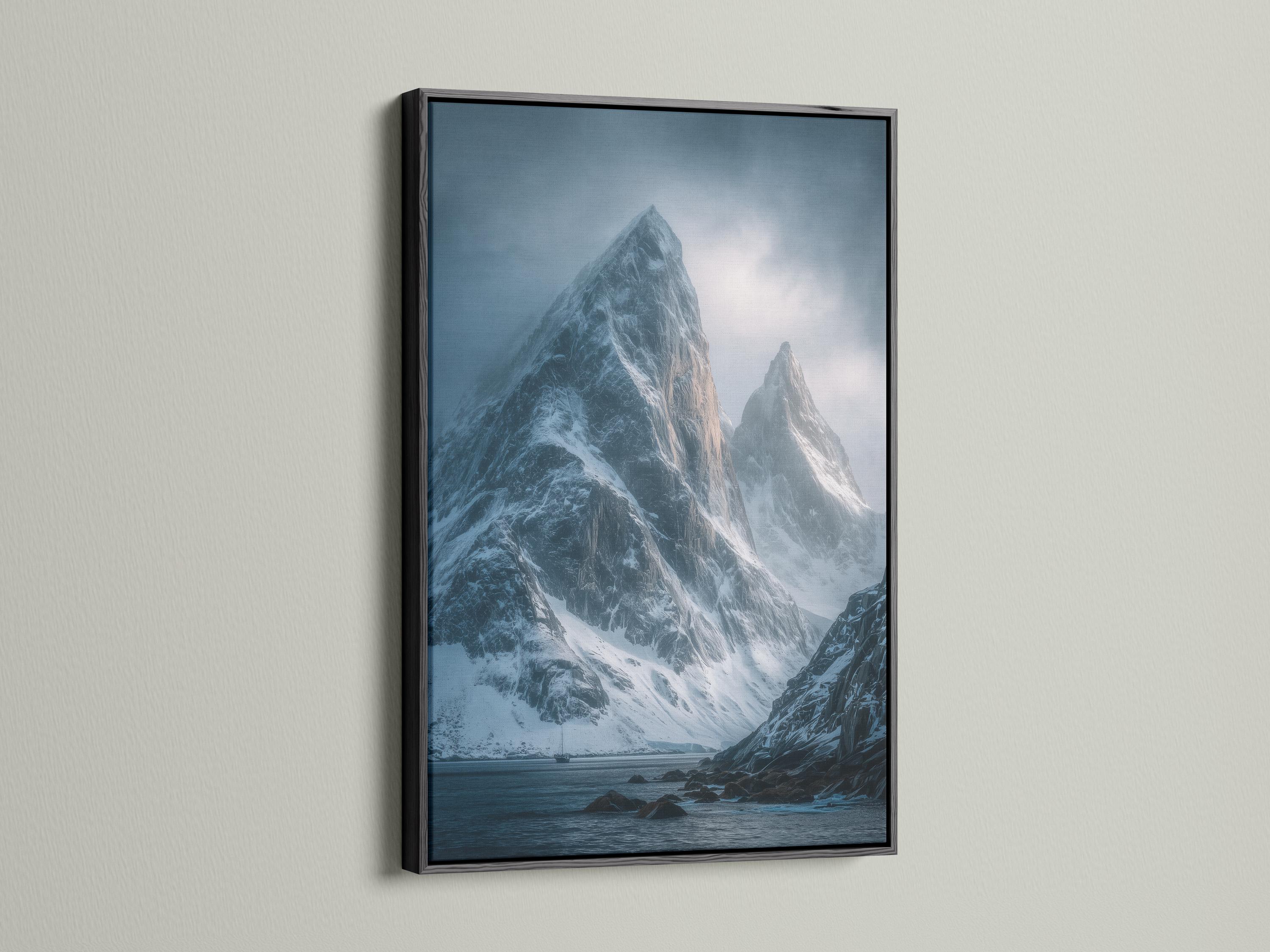 Blue misty mountain landscape with snow peaks, cloudy sky, and dark rocky shoreline detail view