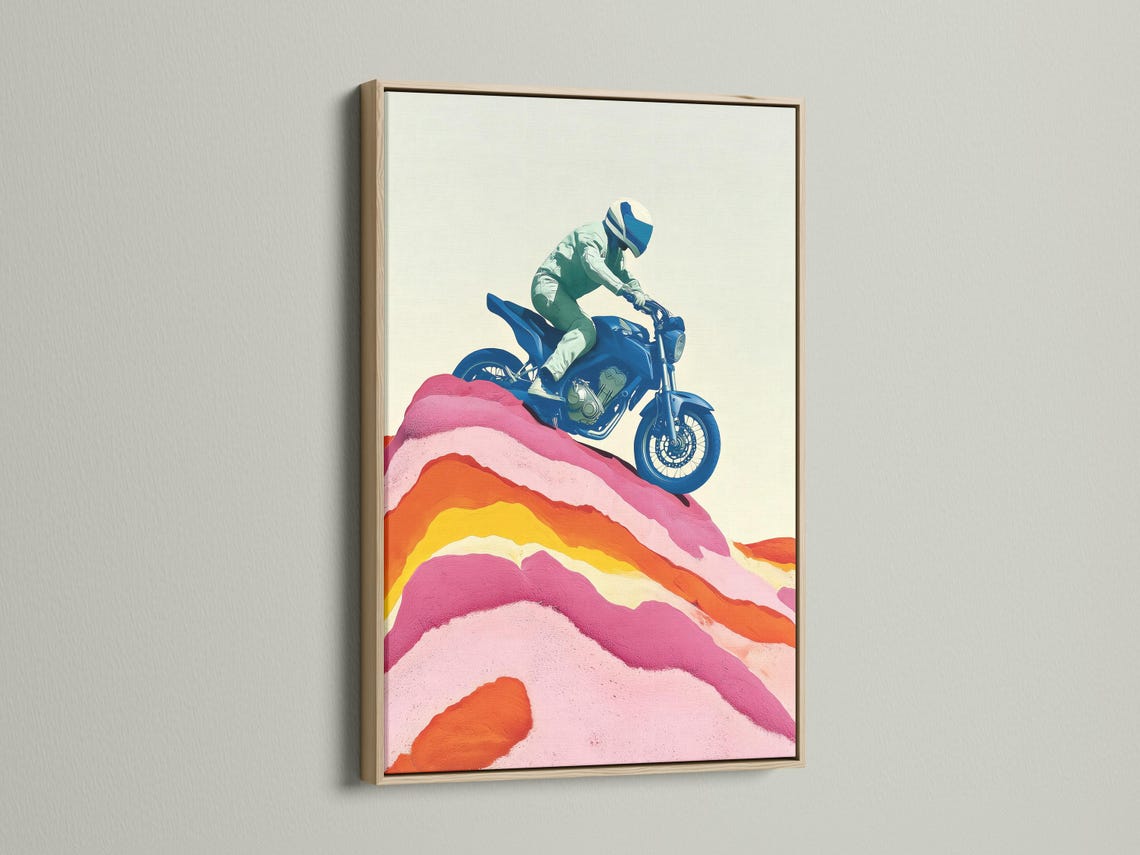 Framed wall mockup showing a stylised blue motorcycle rider over pink and orange mountain ridges