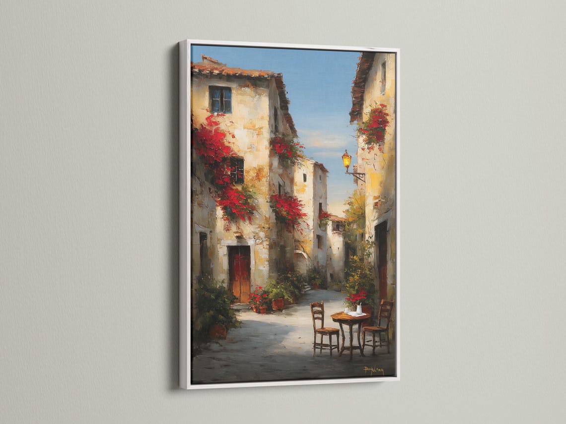 Painterly old-town street scene with red flowers, warm lantern light, and a small café table with chairs detail view