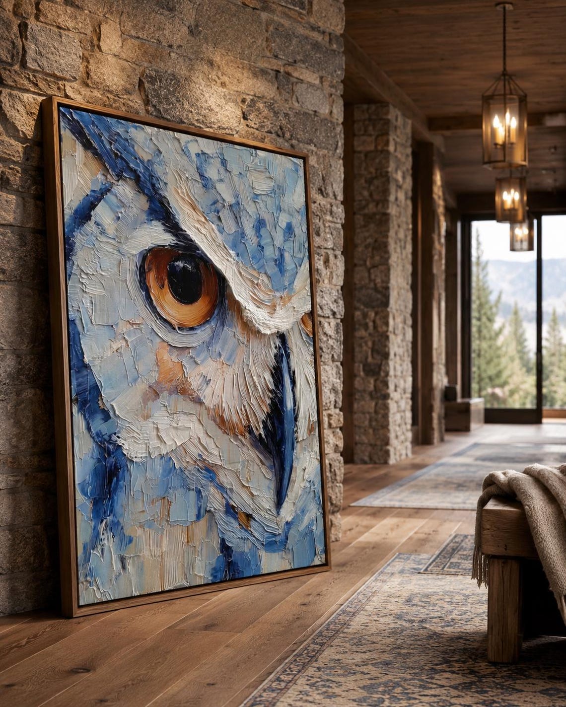 Room scene with a framed blue owl painting above a desk where a person writes in a book