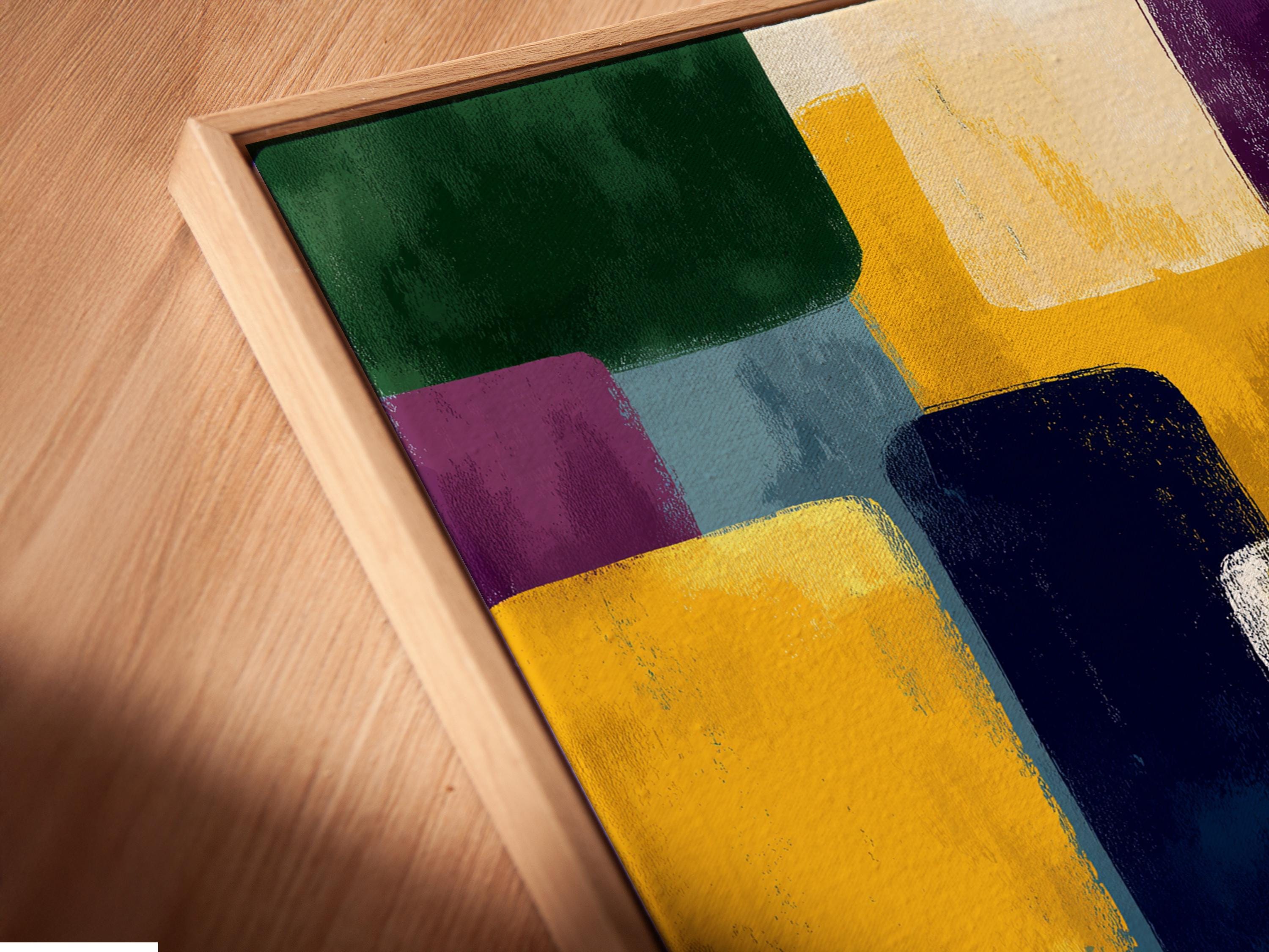A framed geometric abstract artwork features overlapping colourful blocks—green, yellow, purple, blue and white—arranged in an irregular, layered