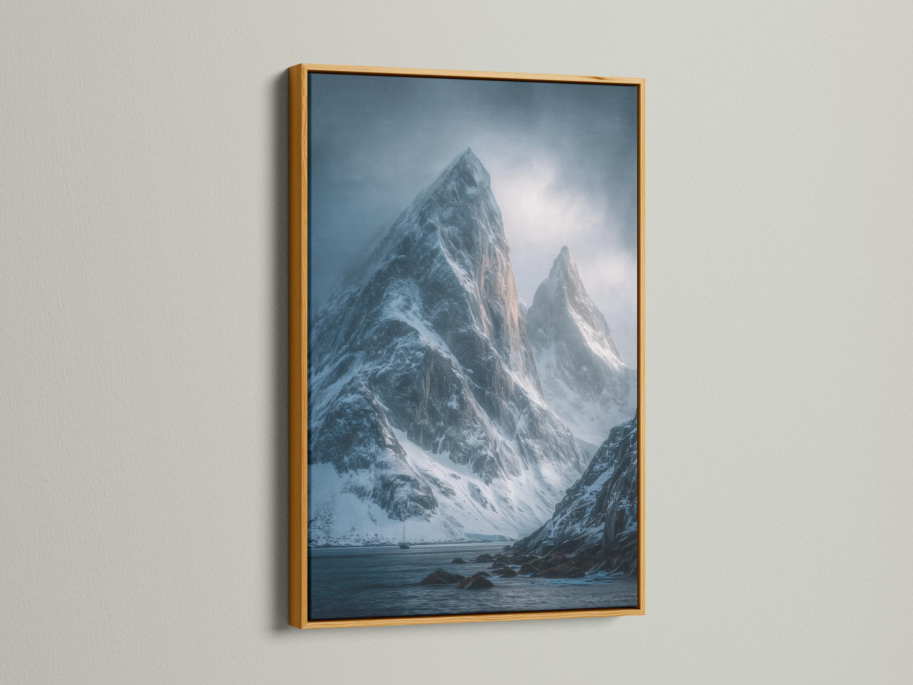 Blue misty mountain landscape with snow peaks, cloudy sky, and dark rocky shoreline detail view