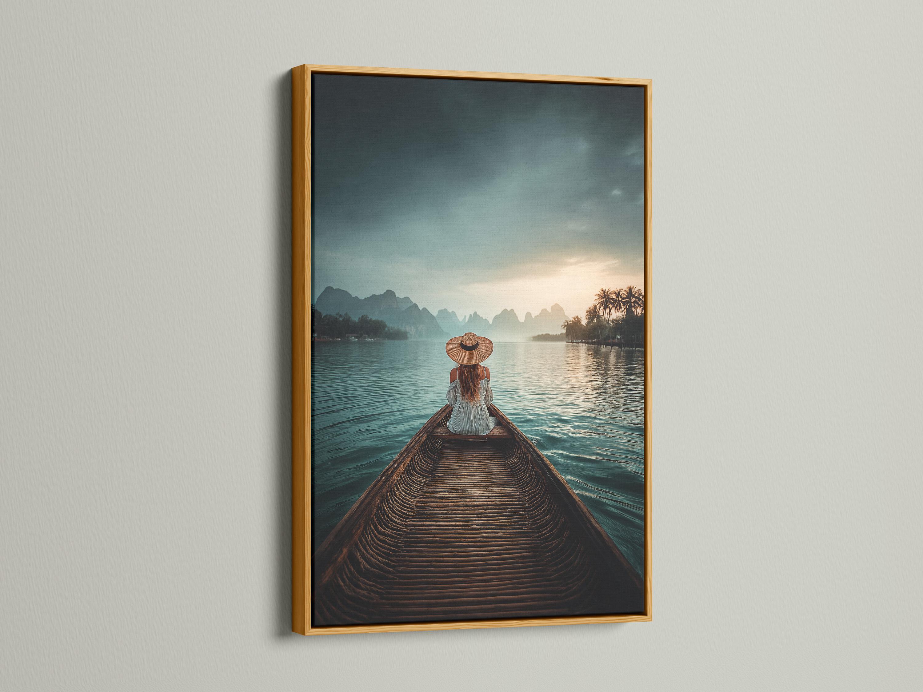 Woman in straw hat sits on a boat facing calm teal water, mountains and a warm sunrise sky detail view