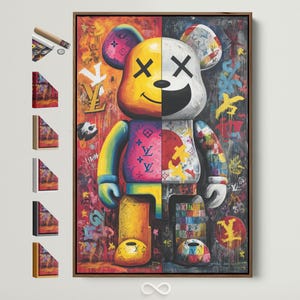 May include: A framed artwork featuring a split-faced bear figure with a yellow and white head, adorned with graffiti-style art. The bear's body is a mix of vibrant colors and patterns, including pink, blue, and yellow. The artwork is in a wooden frame.