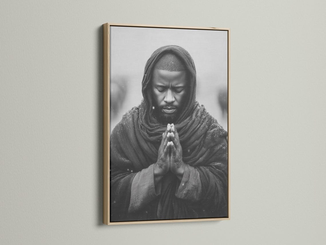 Room mockup showing a framed monochrome praying man portrait on a light background