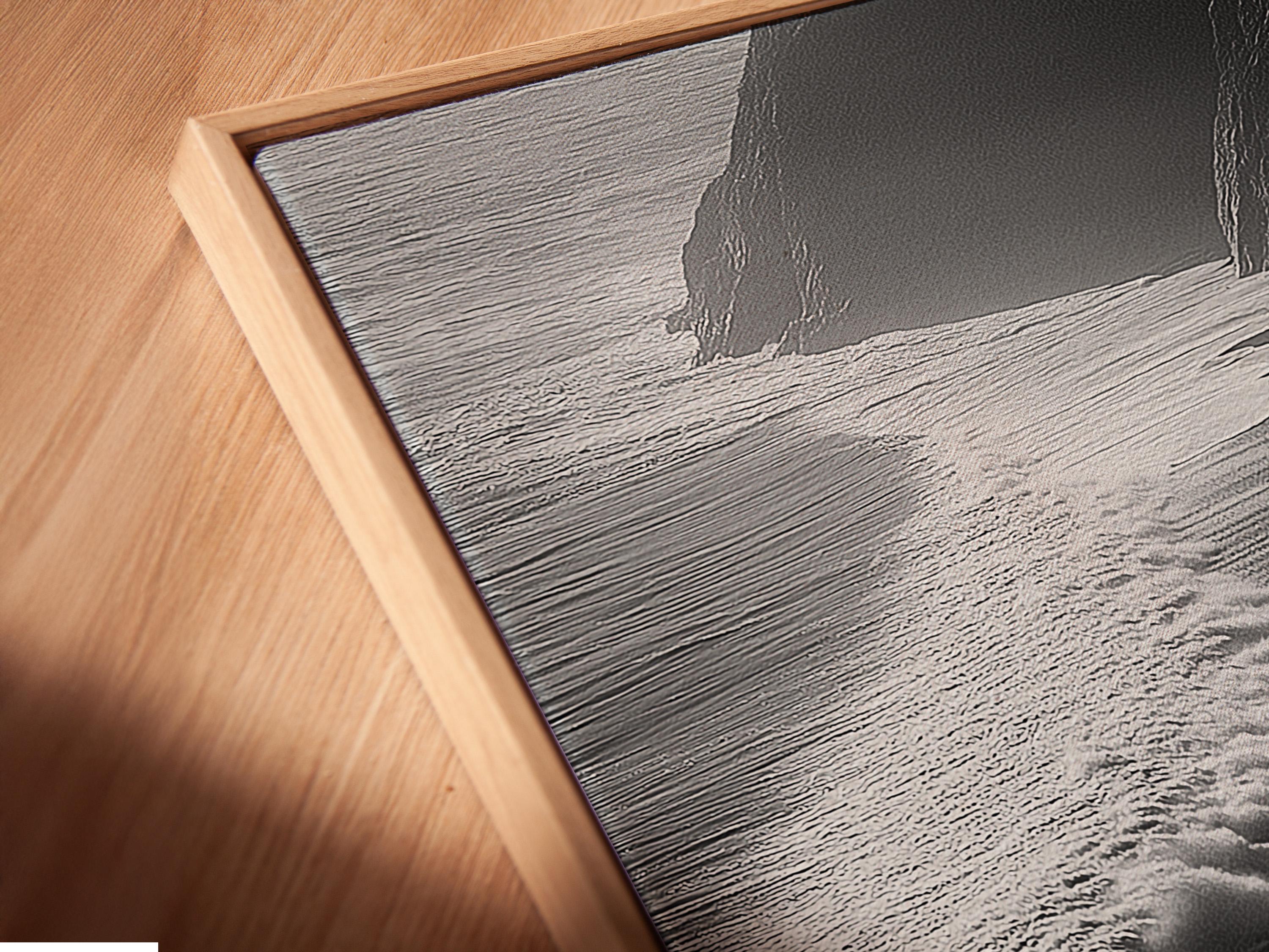 A monochrome seascape shows foamy wave textures breaking along a shoreline, with dark cliff-like shapes framing the scene detail view