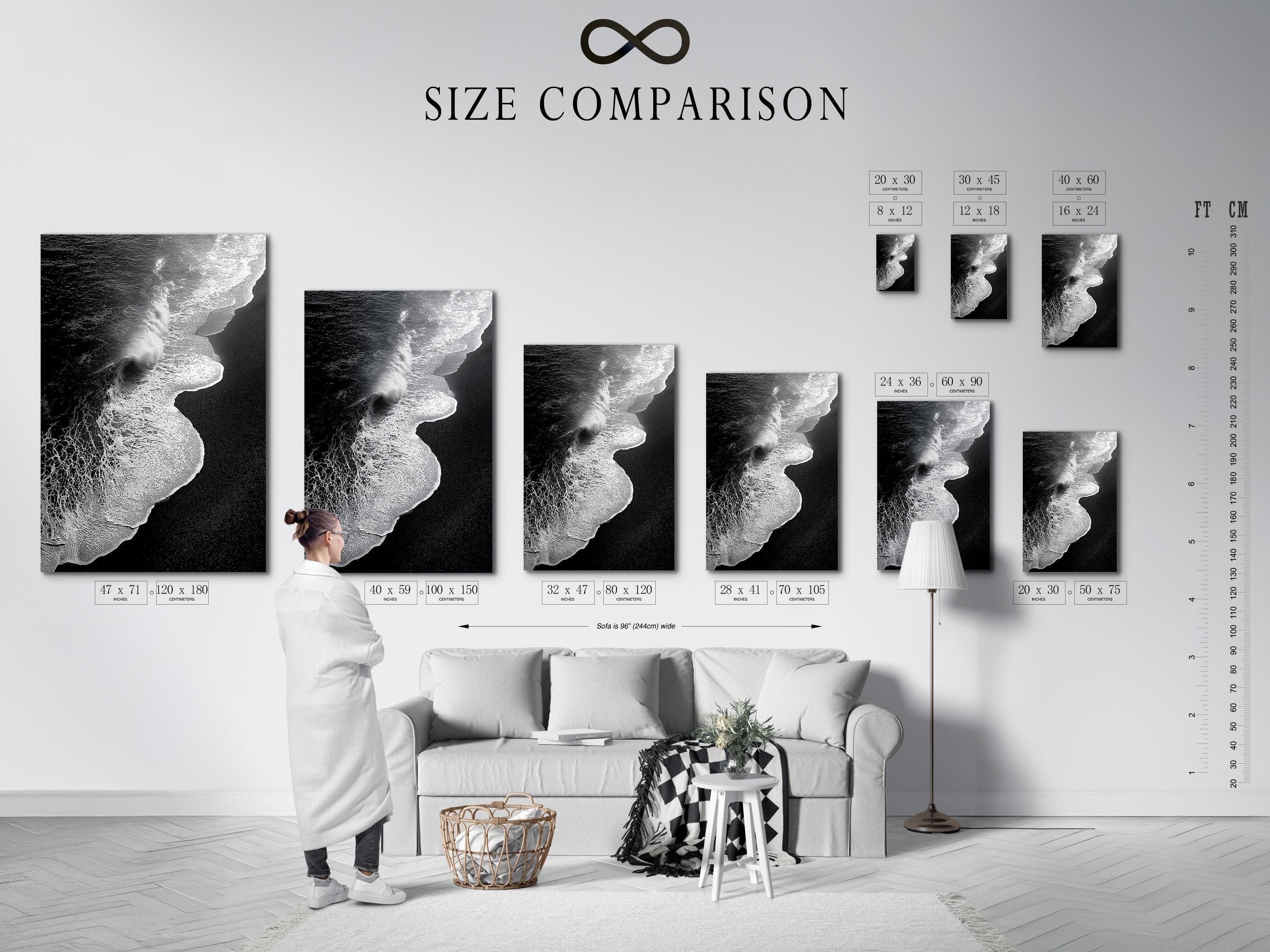 A monochrome seascape shows a foamy wave curling in bright white against deep black water, with a high-contrast, textured finish detail view