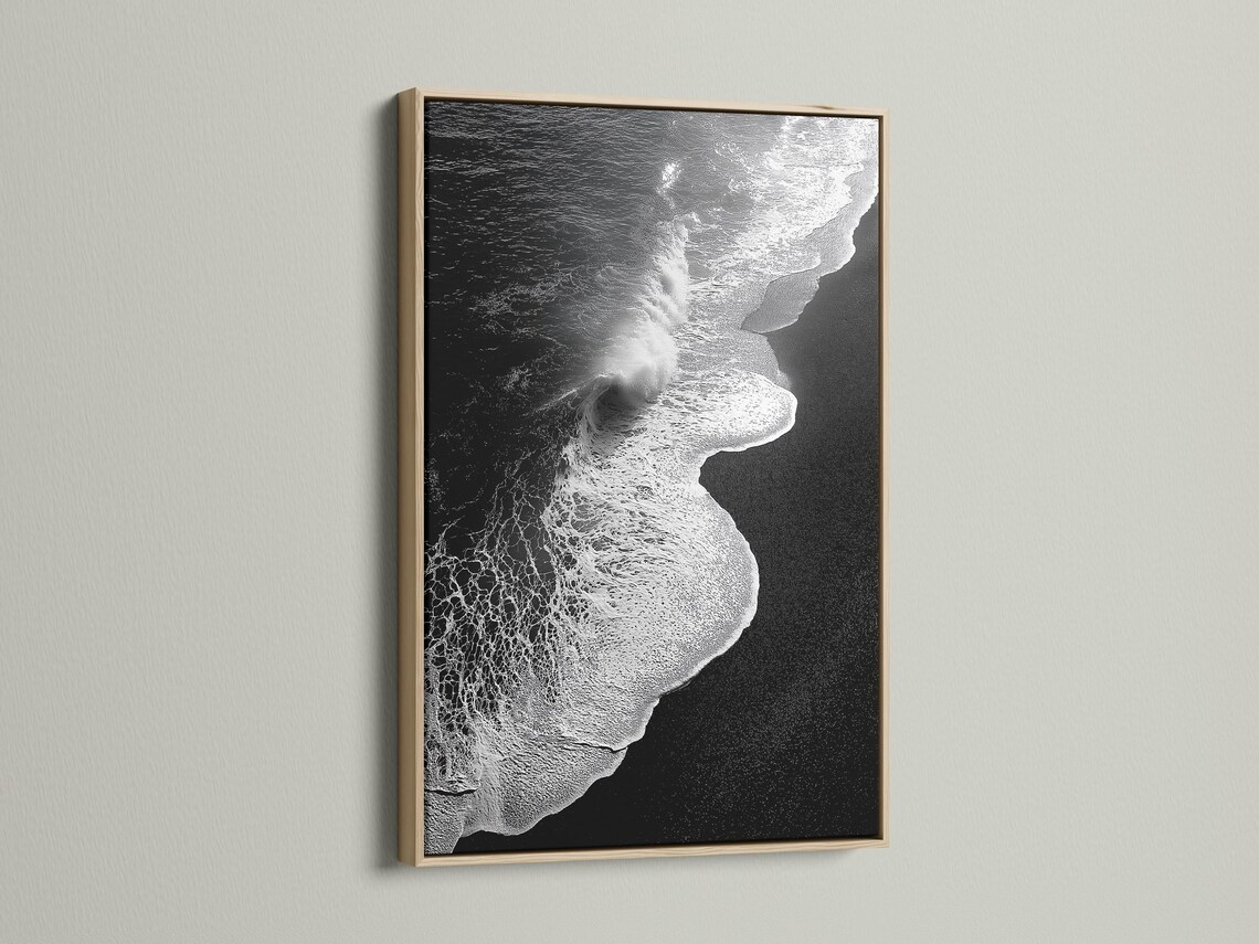 A monochrome seascape shows a foamy wave curling in bright white against deep black water, with a high-contrast, textured finish detail view