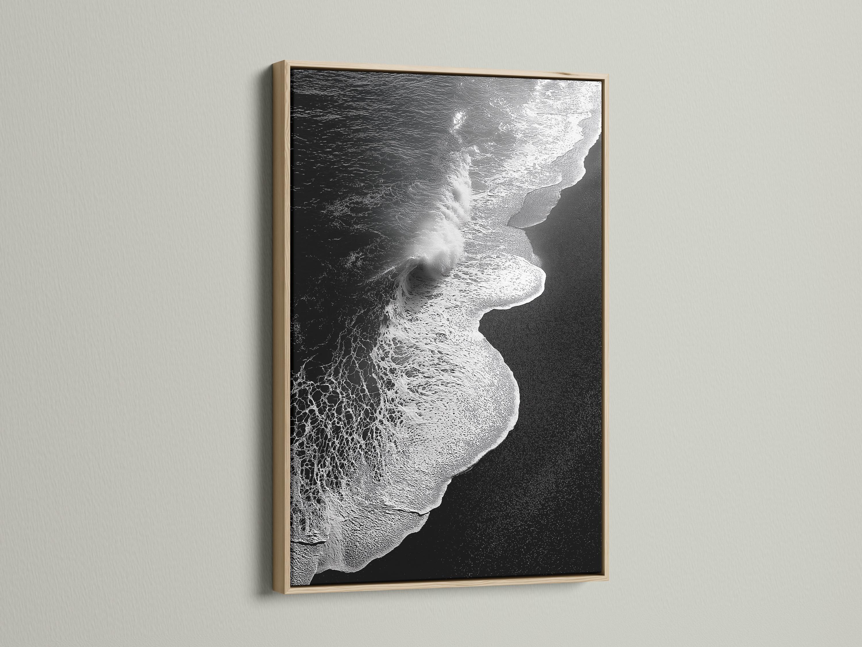 A monochrome seascape shows a foamy wave curling in bright white against deep black water, with a high-contrast, textured finish detail view