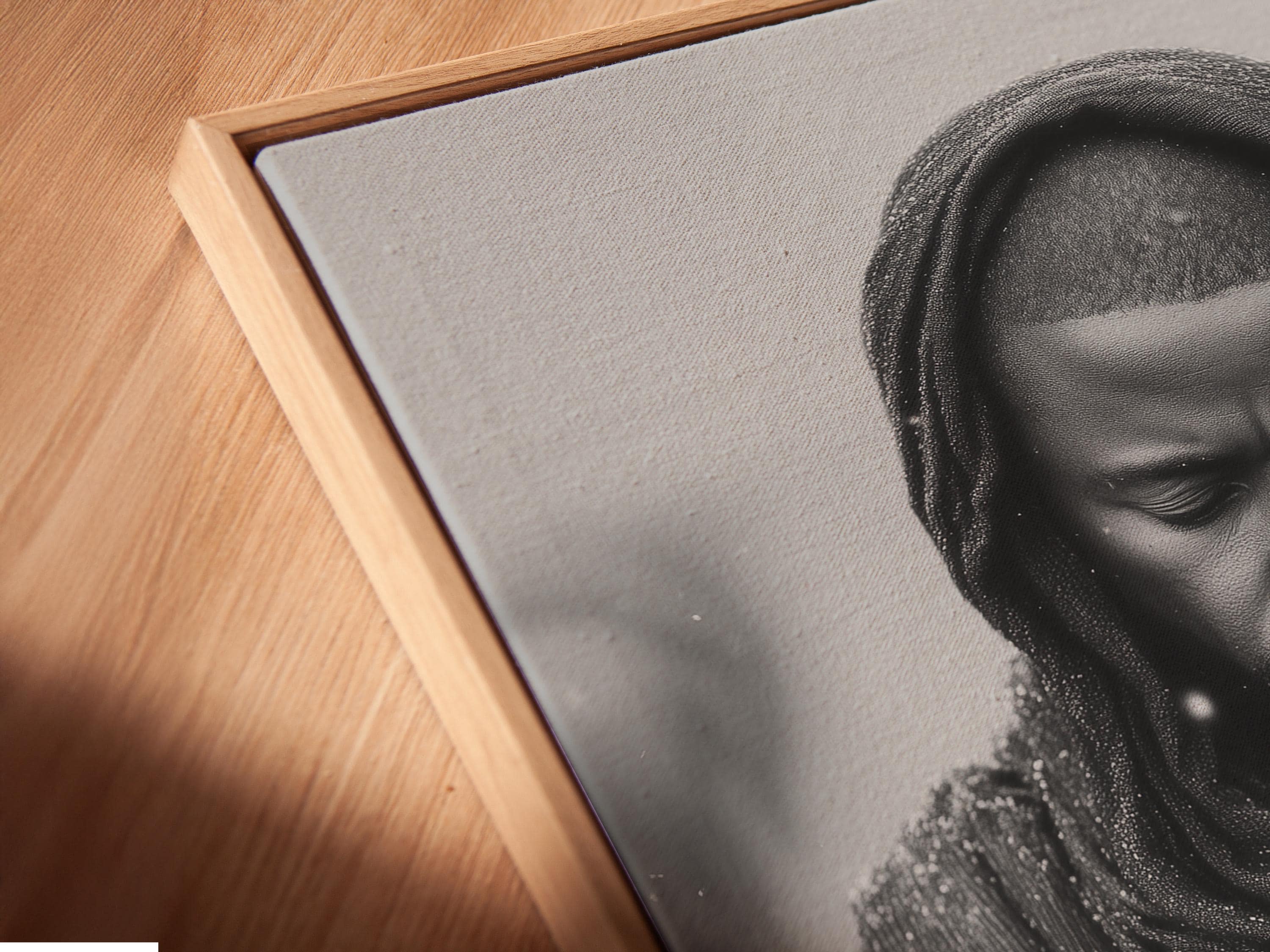 Room mockup showing a framed monochrome praying man portrait on a light background