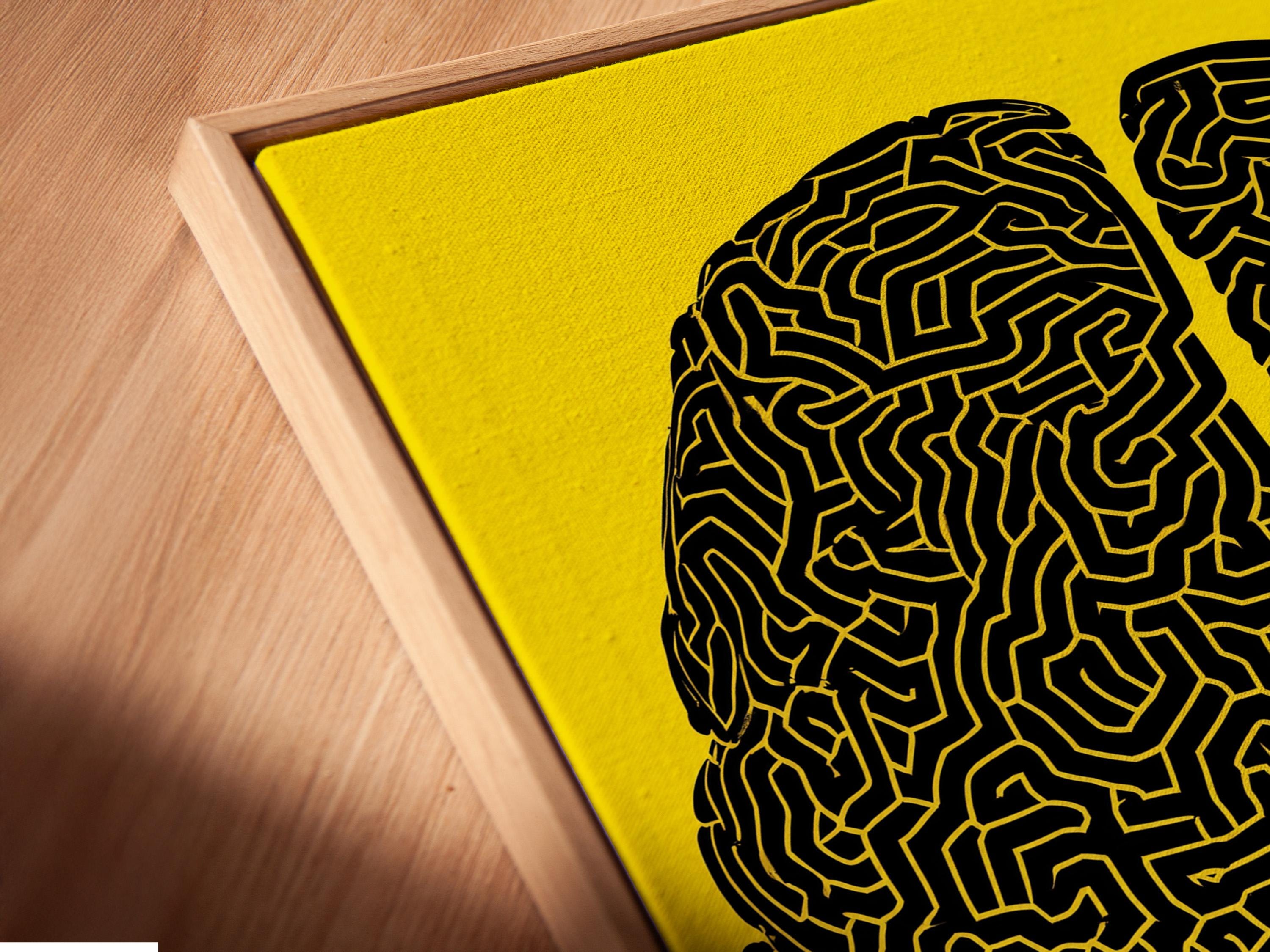 Two black brain silhouettes filled with maze-like lines on a yellow background detail view