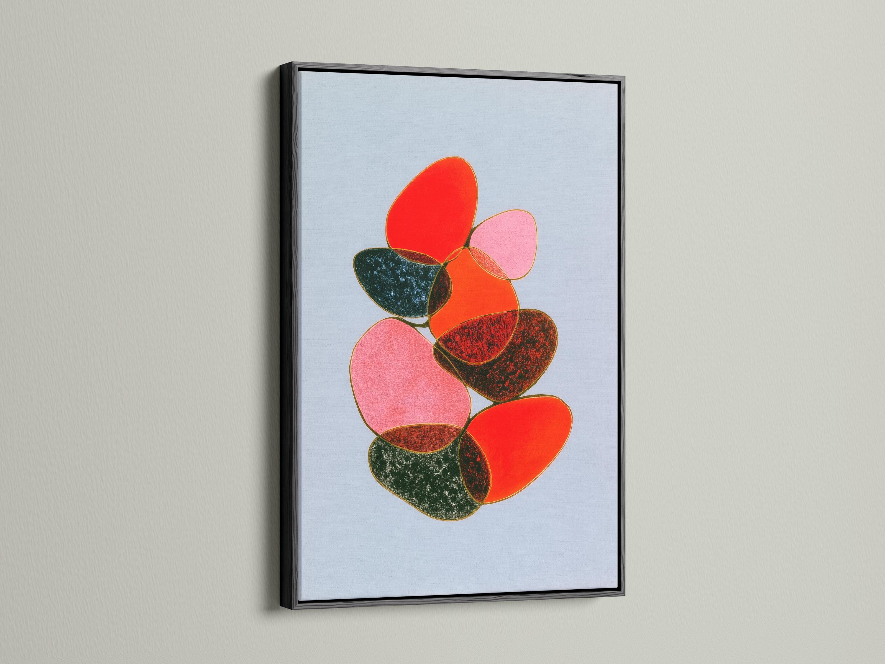Room mockup showing a framed abstract artwork with overlapping red, pink and green shapes on a light blue background