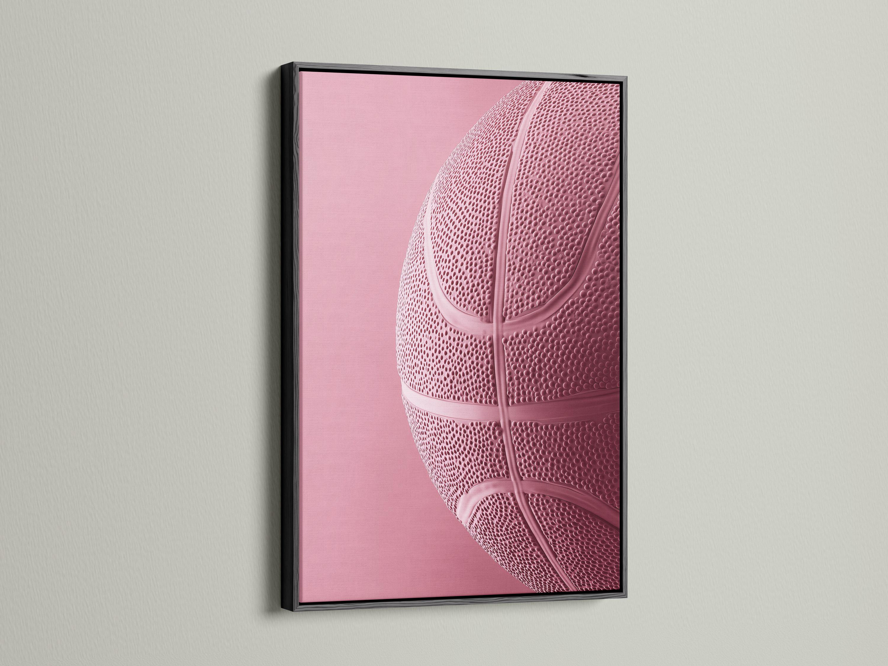 Woman sitting on a sofa beside a framed bubblegum pink basketball artwork