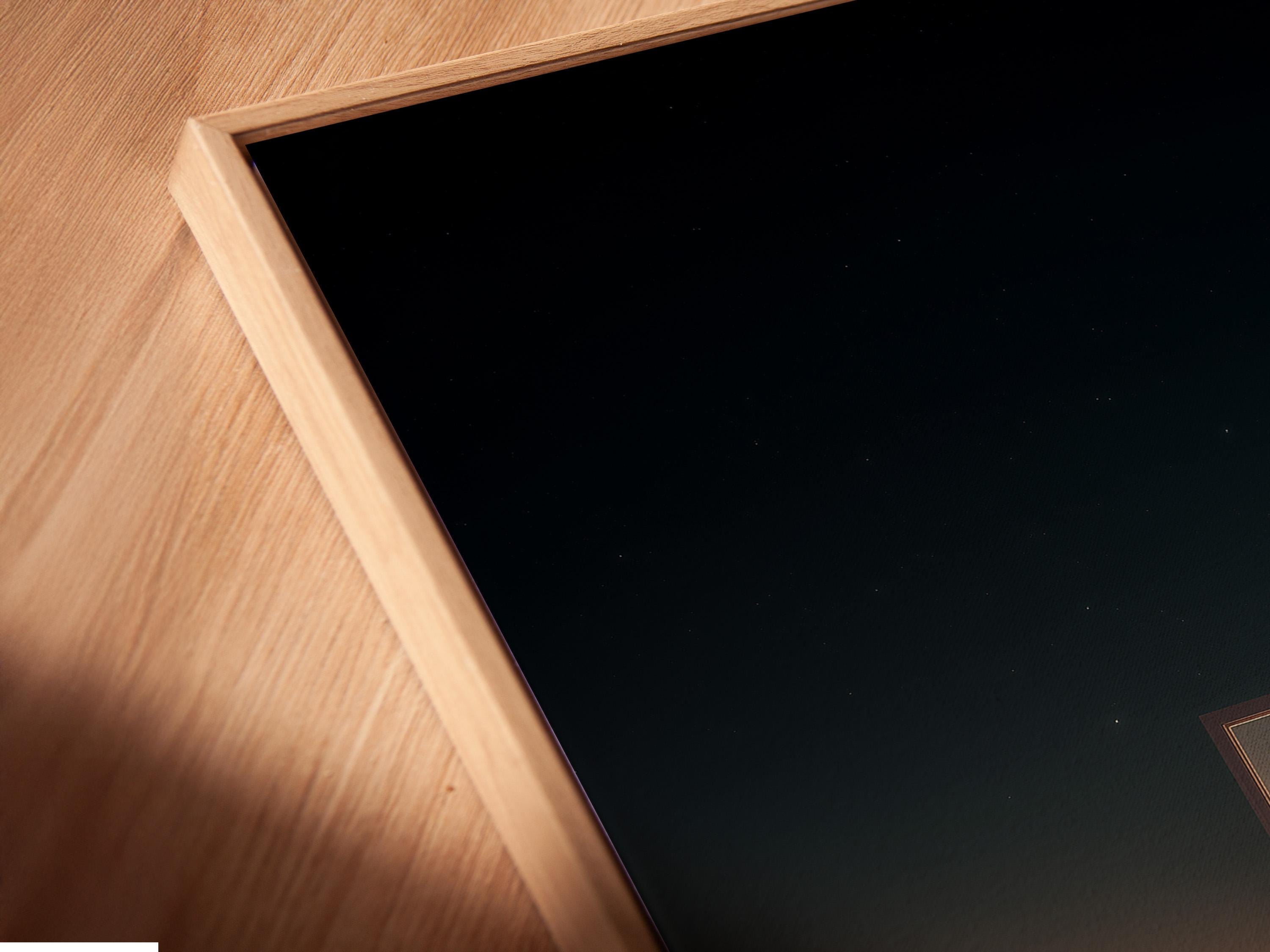 Room mockup showing a framed night seascape with a glowing doorway opening and starry sky