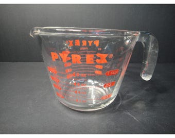 Misurino in vetro Pyrex da 1 tazza (8 once), con scritte rosse e scala metrica standard. Prodotto negli Stati Uniti.