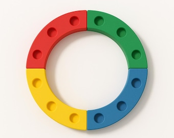 May include: A colorful, segmented ring composed of four curved pieces in red, green, blue, and yellow. Each segment has evenly spaced circular holes. The design is simple and modern, set against a white background.