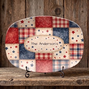 May include: Oval serving platter with a patchwork design in red, white, and blue. The platter features a variety of patterns, including stars and plaid. The text "The Anderson's" is displayed in an oval in the center of the platter.