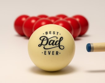 May include: A cream-colored billiard ball with the text "BEST Dad EVER" in black script. Red billiard balls are in the background. A pool cue with a blue tip is in the foreground.
