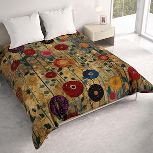 May include: A bed comforter featuring a gold background with a repeating pattern of swirling lines and various colorful flowers including red, blue, yellow, and purple blossoms. Two plain white pillows are positioned at the head of the bed.