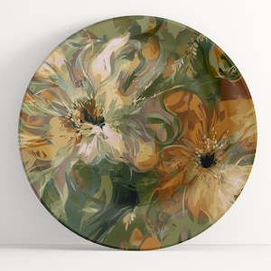May include: Round decorative plate with a floral design. The plate features large, abstract flowers in shades of yellow, brown, and white against a green background. The design has a painterly quality, with visible brushstrokes.