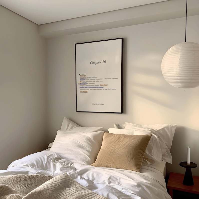 May include: A bedroom scene featuring a bed with white linens and a tan throw and pillow. A framed print with the text "Chapter 26" hangs on the wall. A paper lantern and a candle on a small table complete the scene.