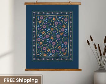 May include: A floral wall hanging with a dark blue background and a wooden frame. The design features a rectangular pattern of colorful flowers in shades of pink, orange, blue, and yellow, with a green border.