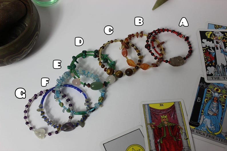 Handmade chakra crystal bracelets arranged with tarot cards