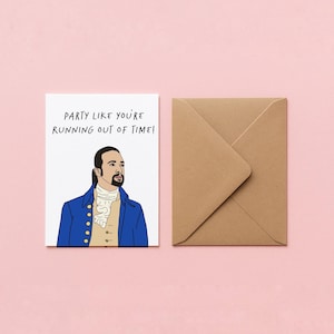 May include: A greeting card with a cartoon illustration of a man in a blue coat and the text "PARTY LIKE YOU'RE RUNNING OUT OF TIME!". A brown envelope is next to the card on a pink background.