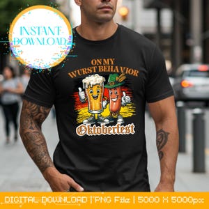 Könnte beinhalten: Schwarzes T-Shirt mit einem Cartoon-Design, das ein Bierkrug und eine Wurst zeigt, die beide den Daumen hochhalten. Der Text lautet "ON MY WURST BEHAVIOR" und "Oktoberfest". Das Design enthält die Farben der deutschen Flagge.