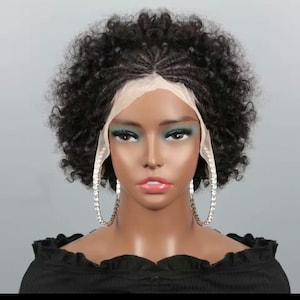 May include: A black curly wig with a lace front is displayed on a mannequin. The wig features a natural-looking hairline and a full, voluminous style. The mannequin is wearing large, silver hoop earrings and a black off-the-shoulder top.