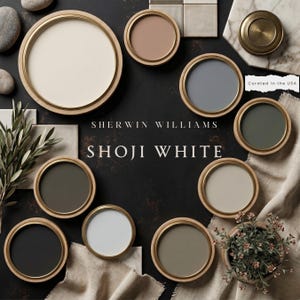 Op de afbeelding: Een Sherwin Williams Shoji White verfpalet met tien cirkelvormige verfstalen in diverse neutrale en gedempte tinten, gerangschikt op een donkere ondergrond met decoratieve elementen zoals stenen, stof en een kleine plant.