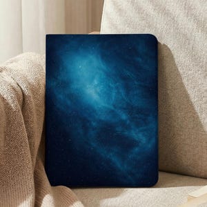 May include: A rectangular tablet case featuring a deep blue and cyan nebula print with scattered white stars. The case has rounded corners and a smooth, matte finish, displaying a cosmic galaxy pattern across the entire front surface.